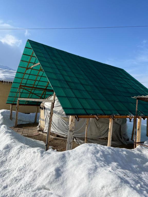 a green roofed tent in the snow at Ak-Suu Eco House in Teploklyuchinskoye