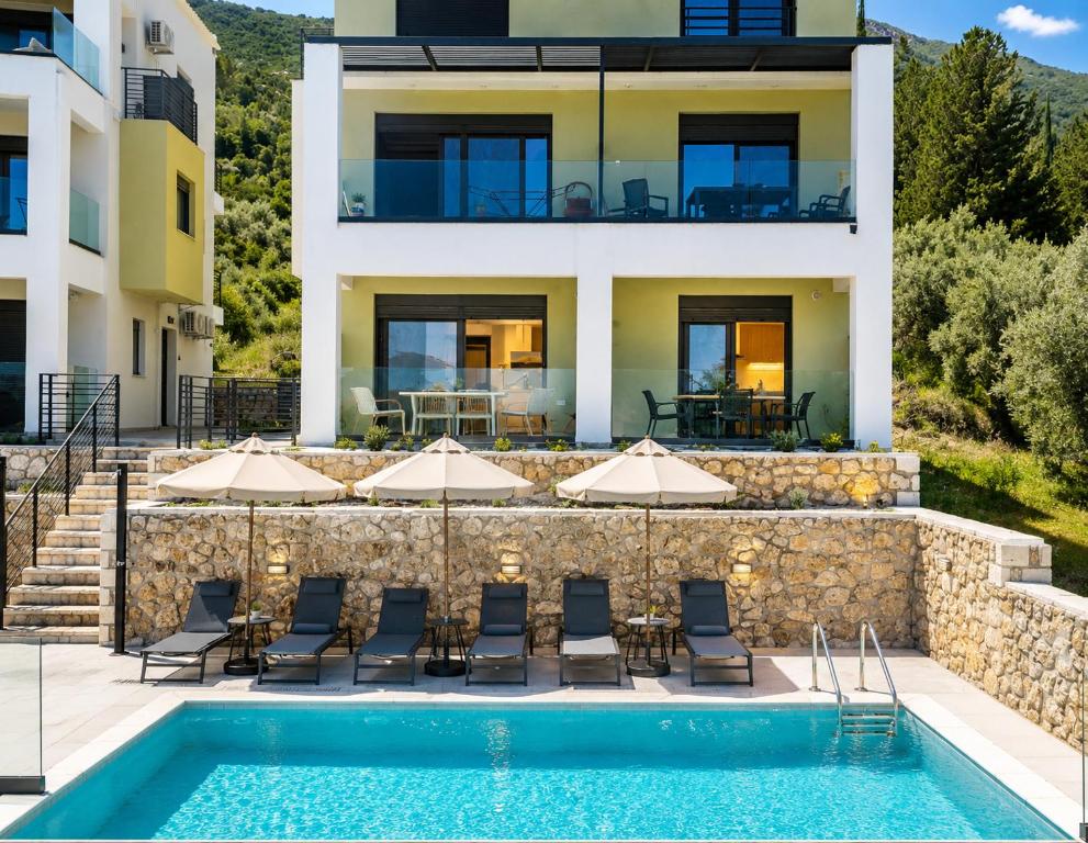 a villa with a swimming pool and a house at Charisma apartments in Nikiana