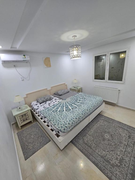 a bedroom with a bed and two rugs in it at Appartement Iris in Gabès