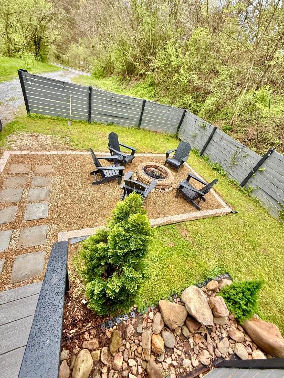 a backyard with three chairs and a fire pit at Charming vacation nest in Sevierville