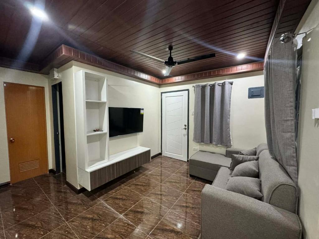 ein Wohnzimmer mit Sofa und Fernseher in der Unterkunft Brians Palace in Tagum