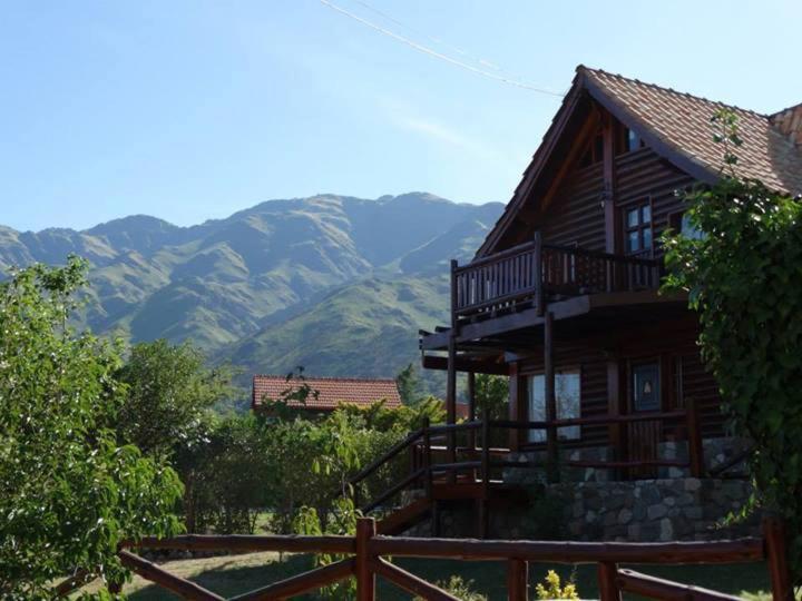 a log cabin with mountains in the background at Casita de Belén in Merlo