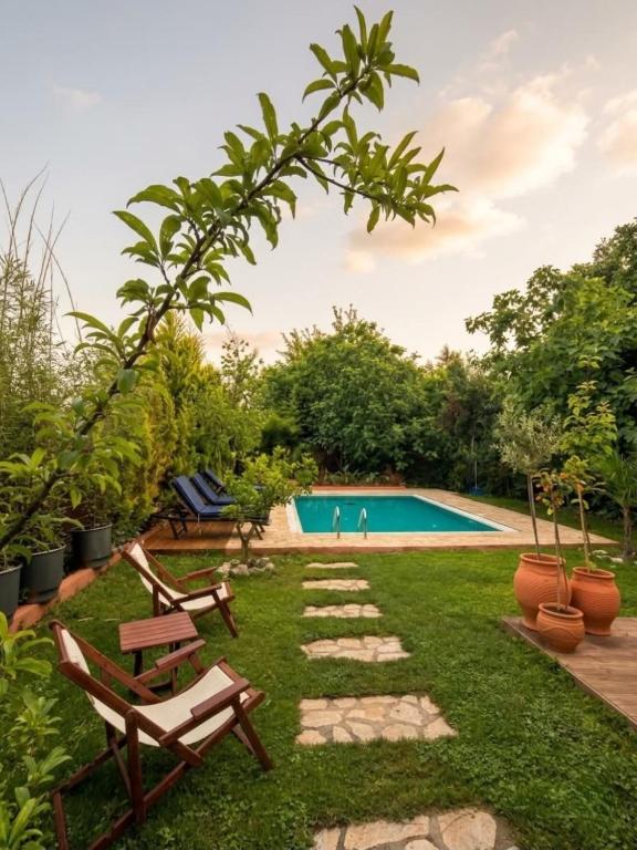 a garden with two chairs and a swimming pool at Villa Hermes in Potamós