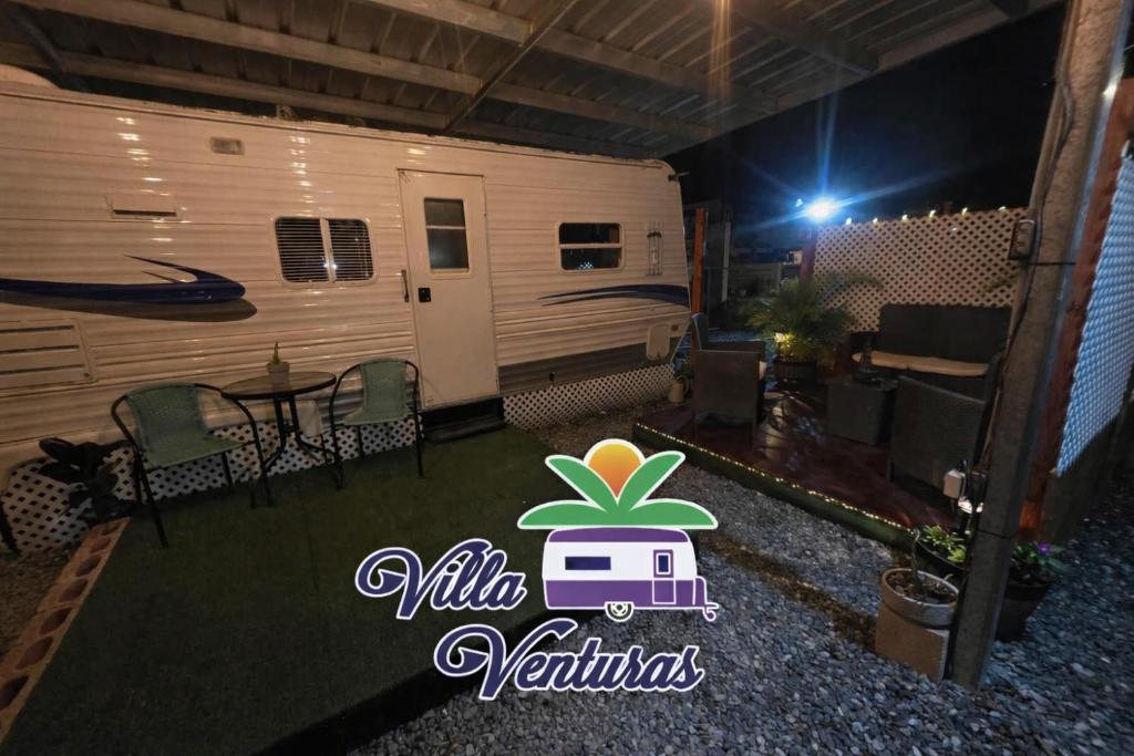 an rv with a table and chairs in front of it at Villa Venturas in Cabo Rojo