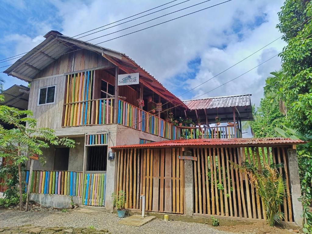 ein Holzhaus mit einem Balkon auf dem Dach in der Unterkunft Hospedaje Rural Shihumar in Coquí
