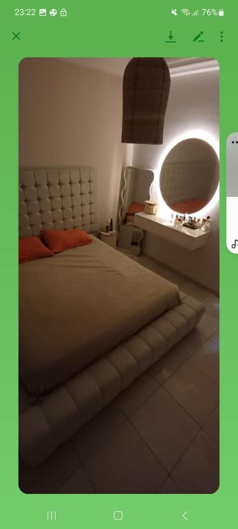 a bedroom with a large bed and a mirror at Villa n 5 in Sidi Daoud