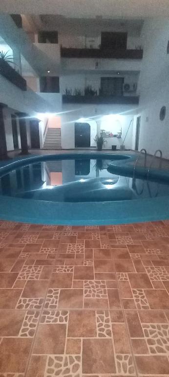 a large swimming pool with a tile floor in a building at CONDOMINIO SÁBALO VISTA in Mazatlán