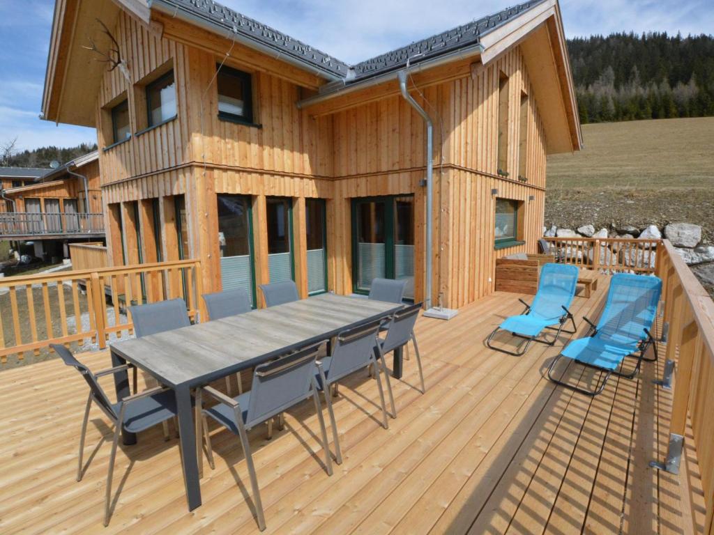 a wooden deck with a table and chairs on it at Lachende Eule in Hohentauern