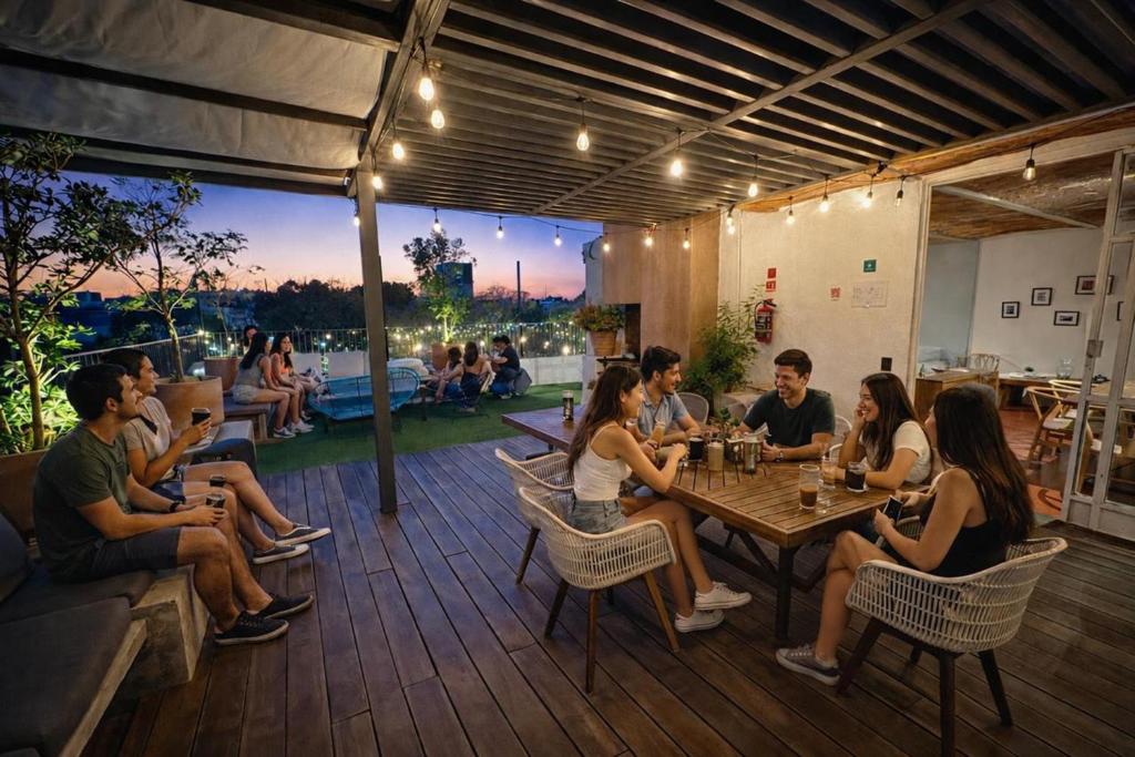 a group of people sitting at a table on a patio at Hostal Nube Mia Guadalajara in Guadalajara