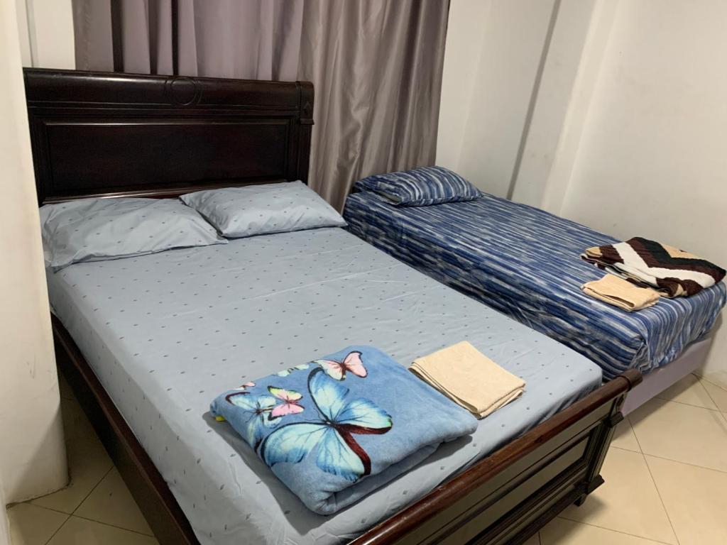 two twin beds in a bedroom with towels on them at Hostal Belletini in Manta