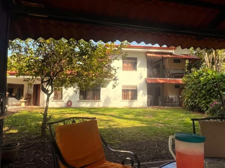 a table and chairs in front of a house at Blue Palm Bed & Breakfast in Barrio Jesús