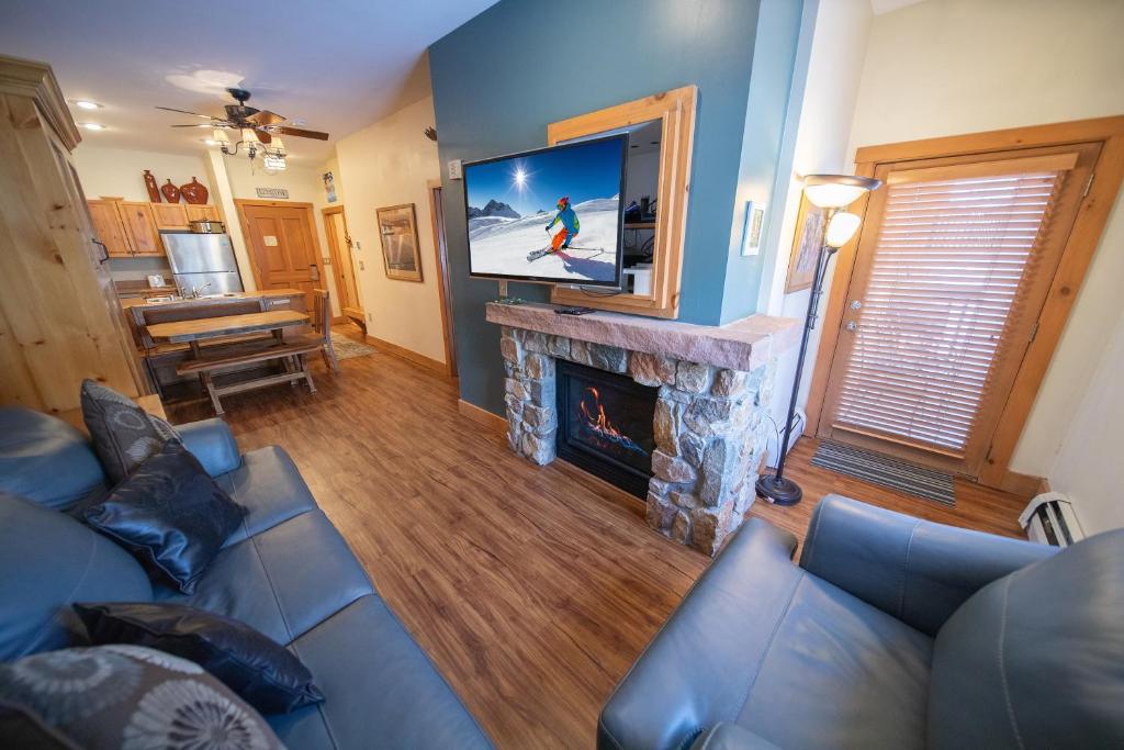 a living room with a blue couch and a fireplace at Expedition Station 8554 by SummitCove Lodging in Colorado in Keystone