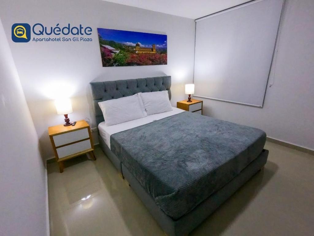 a bedroom with a bed and two night stands with lamps at Apartamentos Quedate en Anavi San Gil Plaza in San Gil