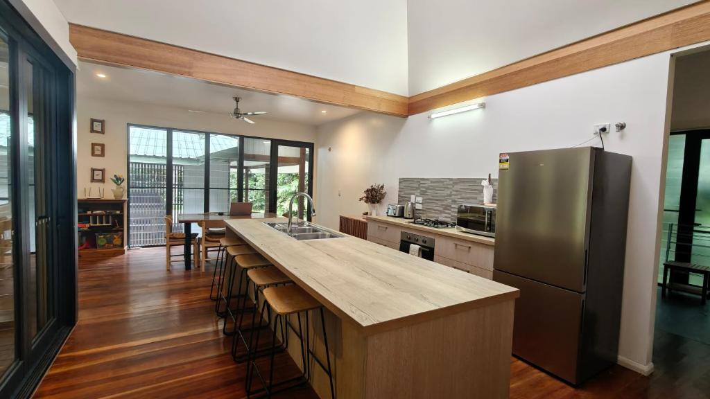a kitchen with a stainless steel refrigerator and a counter at Rainforest Escape moments from Waterfall in Kuranda