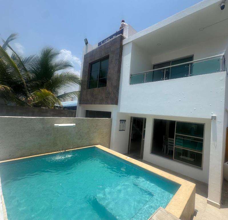a swimming pool in front of a house at Hostel La Catalina Plus - frente al mar in Cartagena de Indias