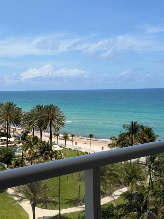 a view of the beach from the balcony of a resort at Ocean front Condo with balcony on the beach in Sunny Isles Beach
