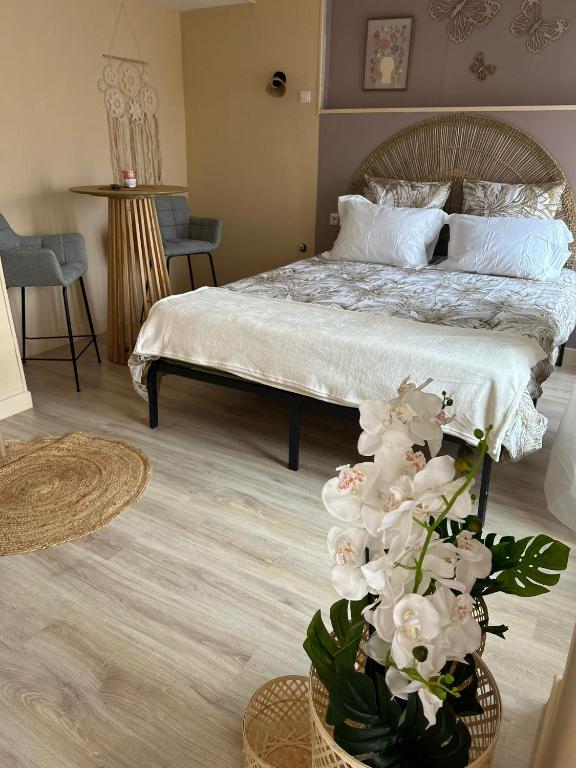 a bedroom with a bed with a vase of flowers at Le nid gourmand in Andryes
