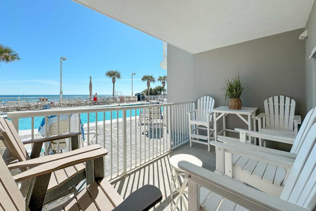 a balcony with chairs and a view of the beach at BeachFront, Bottom Level Condo at Tradewinds in Orange Beach