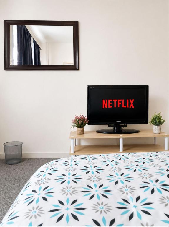 a television sitting on a table in a bedroom at Stylish Room in Wolverhampton opp Asda in Wolverhampton