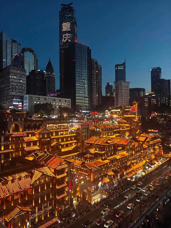 a city lit up at night with buildings and cars at Kaboting Hotel Chongqing Prime Location Near Jiefangbei & Hongya Cave, 1 Minute Walk to Metro, Ideal for International Guests,Free Self-Service Laundry, Free High-Speed WiFi,Free Chinese Tea, Free Travel Advice in Chongqing