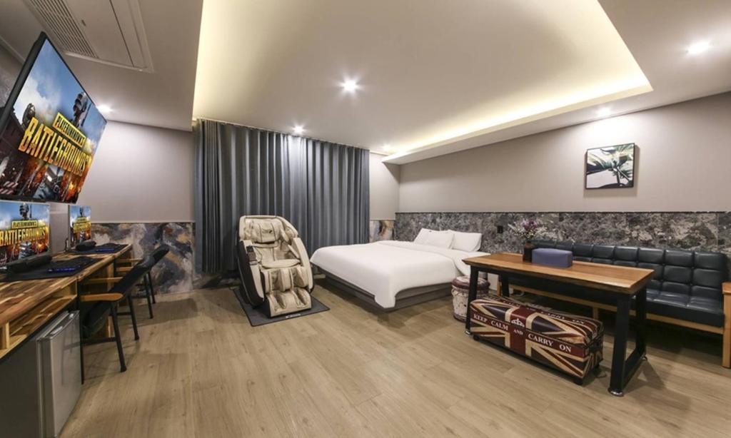 a hotel room with a bed and a couch at Daegu Seongseo Hotel Series 5.0 in Daegu