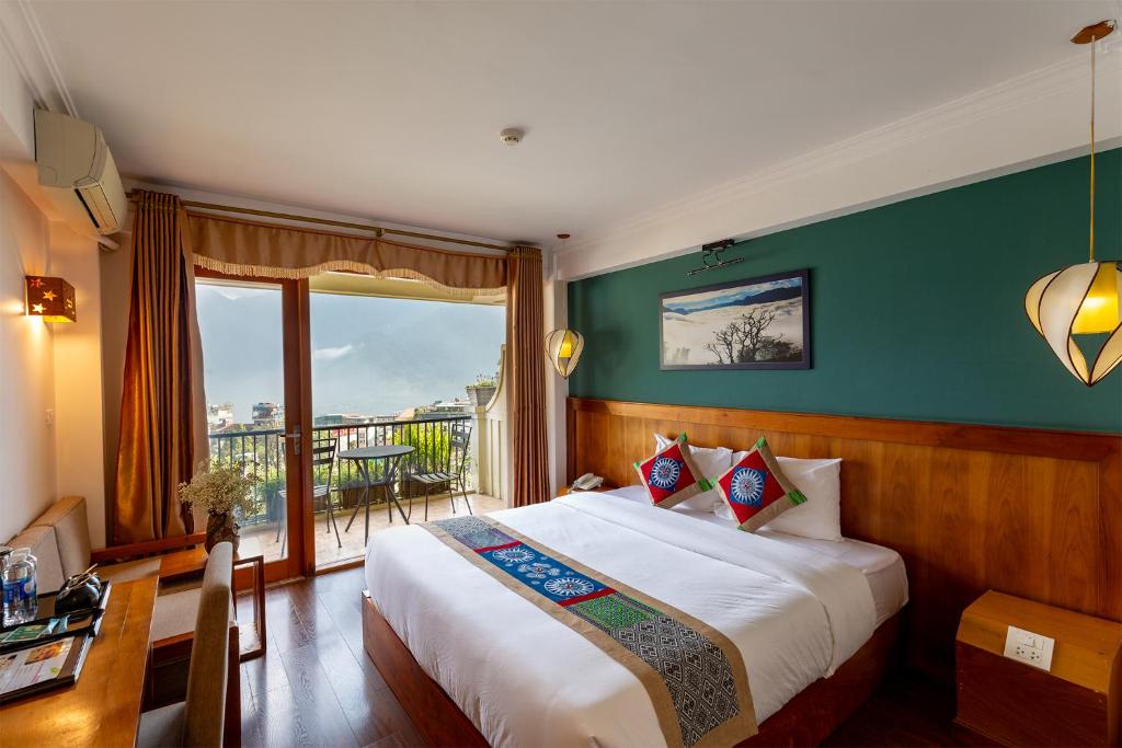 a bedroom with a large bed and a balcony at Sapa Panorama Hotel in Sapa