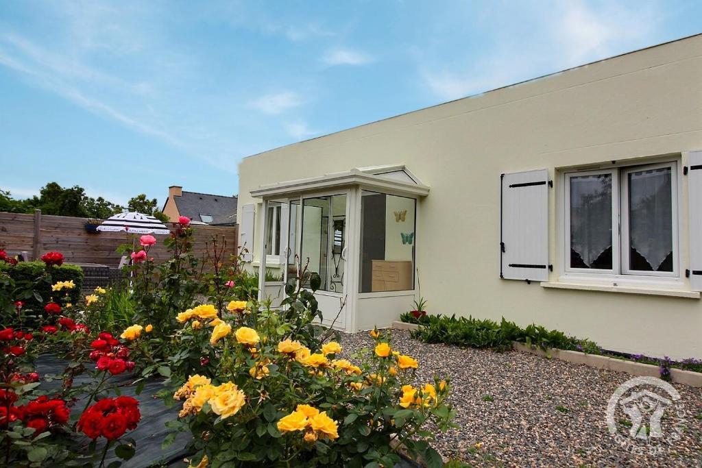 a house with flowers in front of it at Les papillons in Plérin