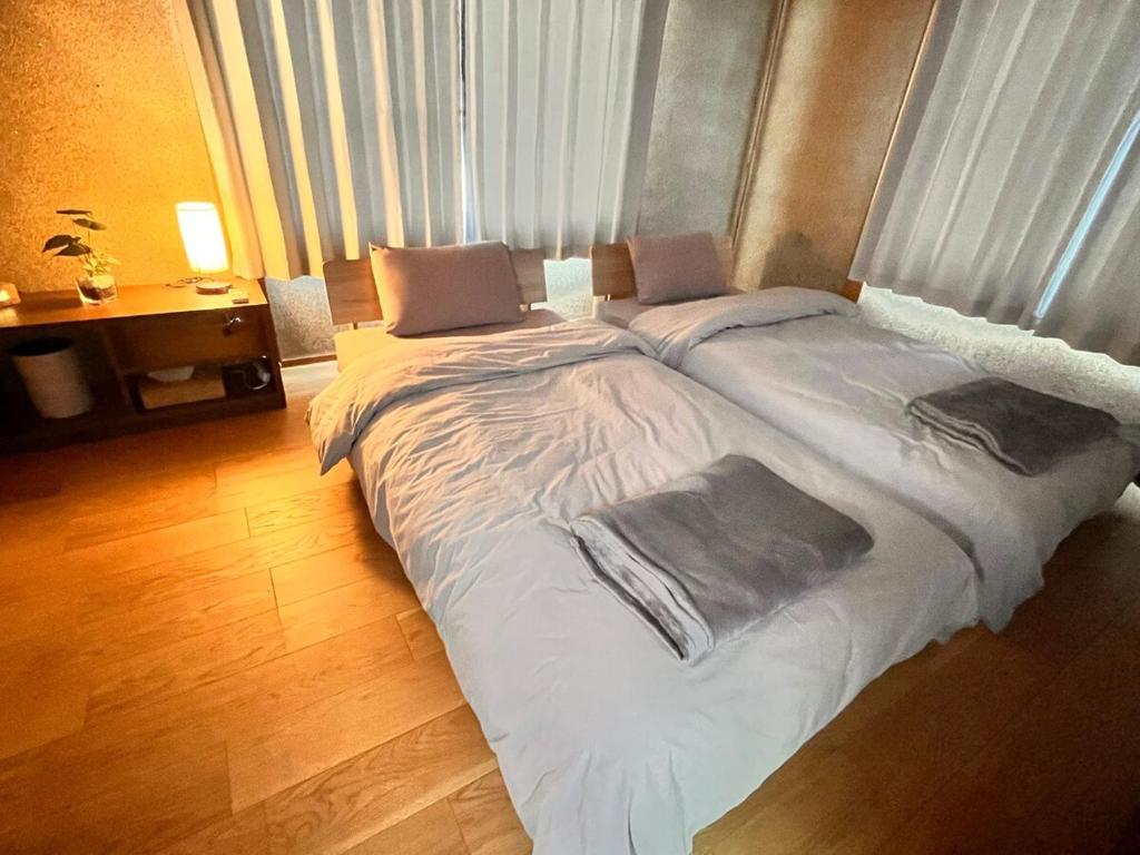 two twin beds in a room with a window at 城下の宿庵 in Ōzu
