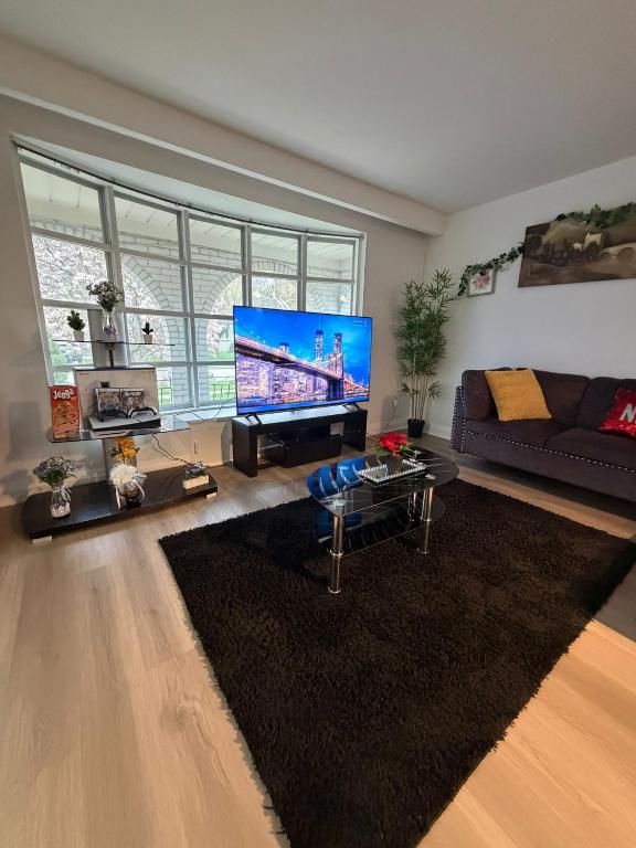 a living room with a large flat screen tv at Luxury Fun Villa in Toronto