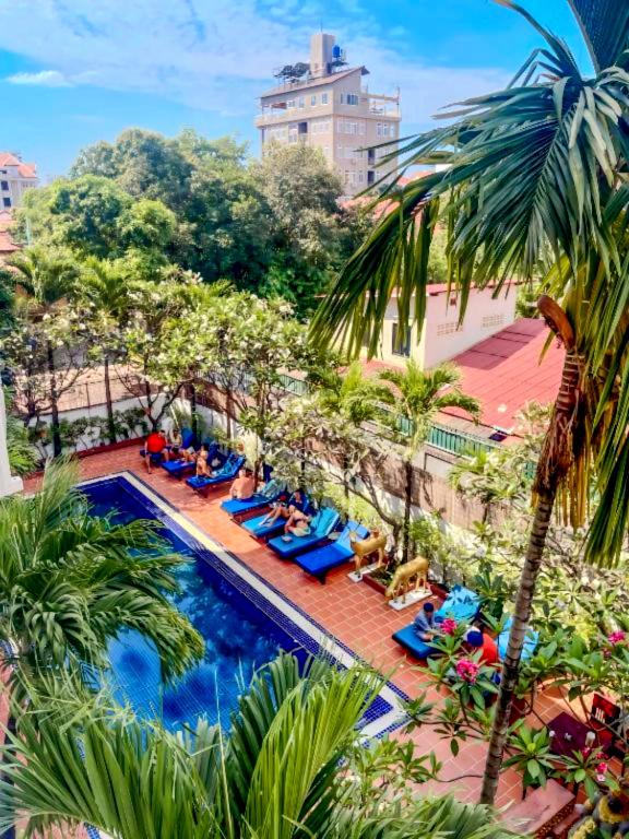 a group of people laying around a swimming pool at Harmony Hotel in Siem Reap