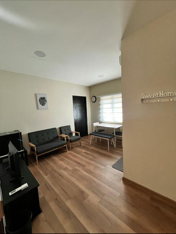 a living room with a couch and chairs in a room at JEC Suites in Kuching