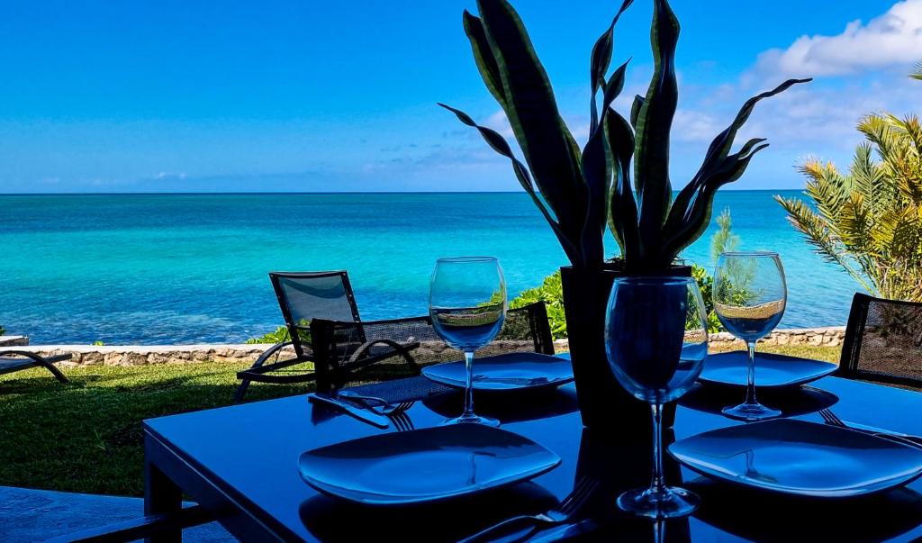 a table with wine glasses and a vase with a plant at Sand Star in Russel Island