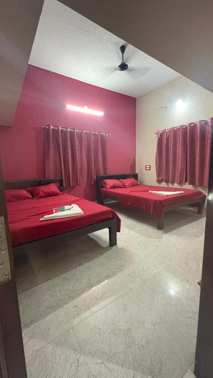 two beds in a room with pink walls at Vanasiri stay inn in Sringeri