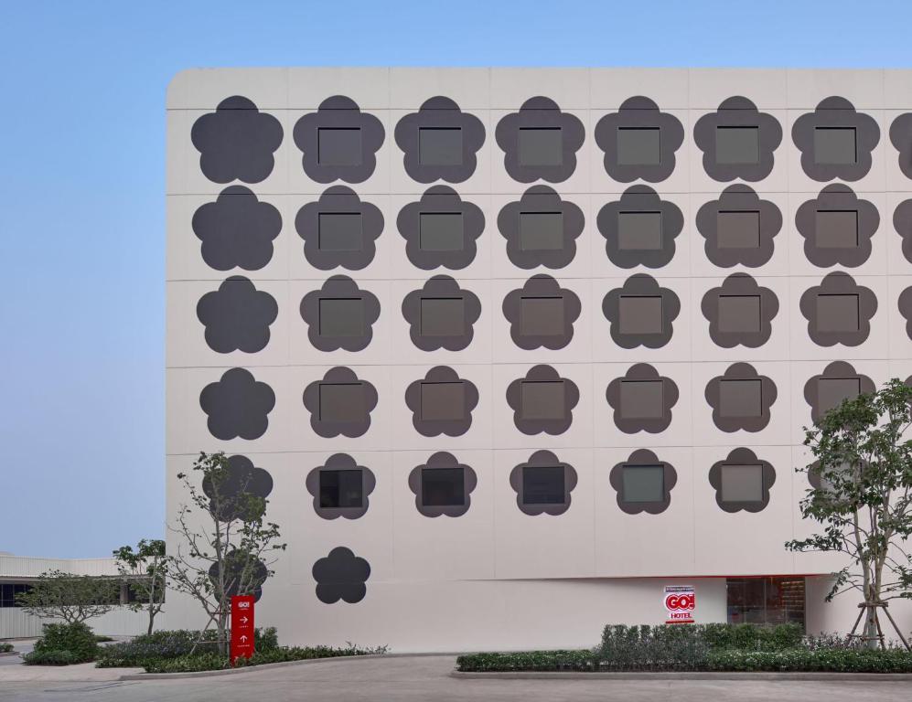 a building with a wall with black logos on it at Go Hotel Khon Kaen Campas in Ban Nong Waeng