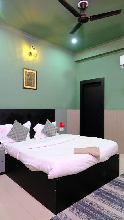 a bedroom with a large bed with white sheets at Quiet Corner 4BHK Villa in Lucknow