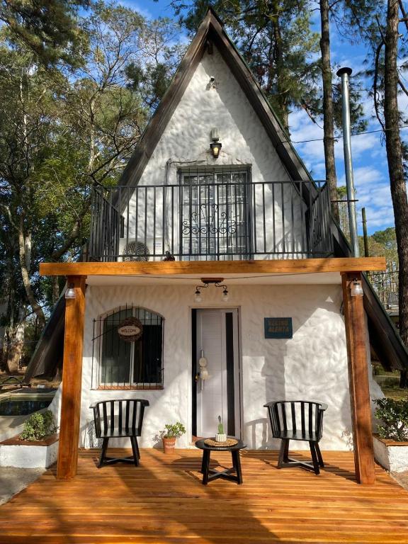 a house with a balcony and two chairs on a deck at La Alpina playa Nebel in Concordia