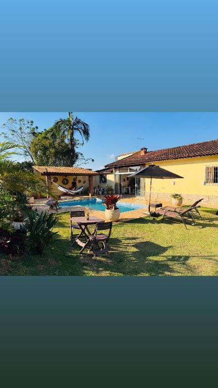 a backyard with a picnic table and a pool at Chácara Nunes in Ibiúna