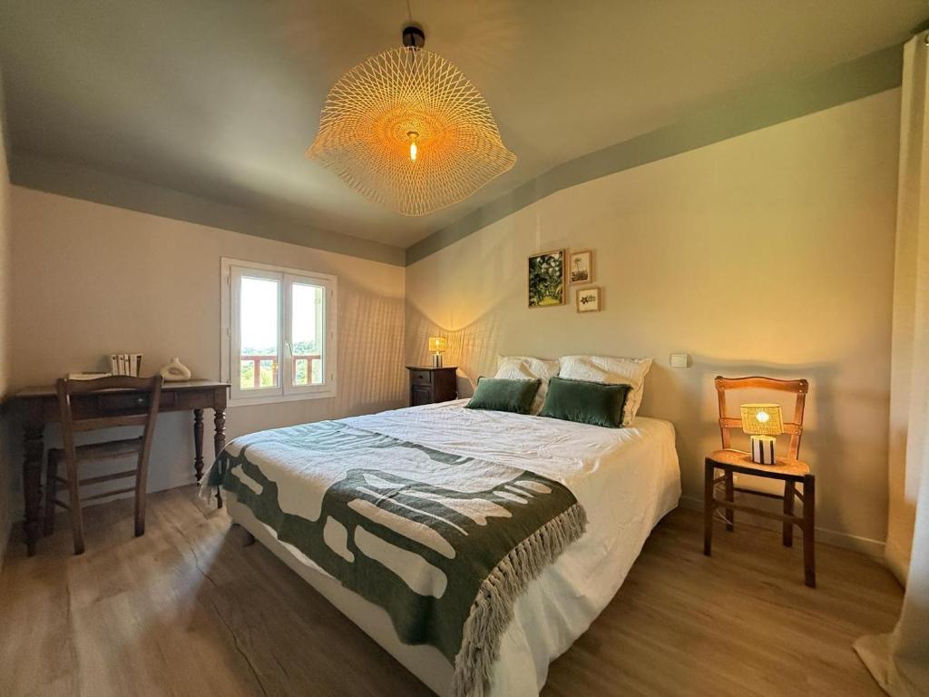 a bedroom with a bed and a desk and a chandelier at Pegartea in Mendionde