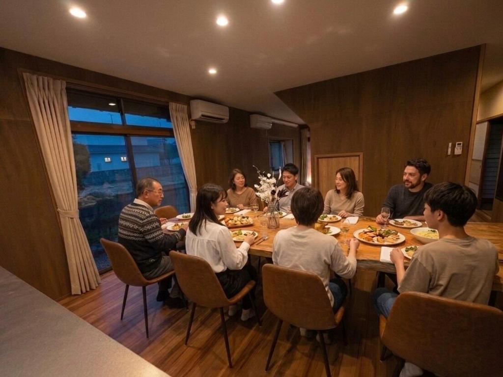 a group of people sitting around a table eating at Yoike Stay in Yonago