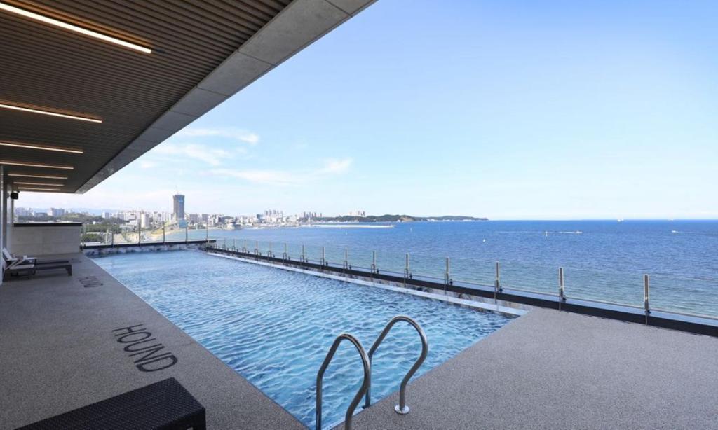 a swimming pool with a view of the ocean at Pohang Hound Hotel Songdo Beach in Pohang