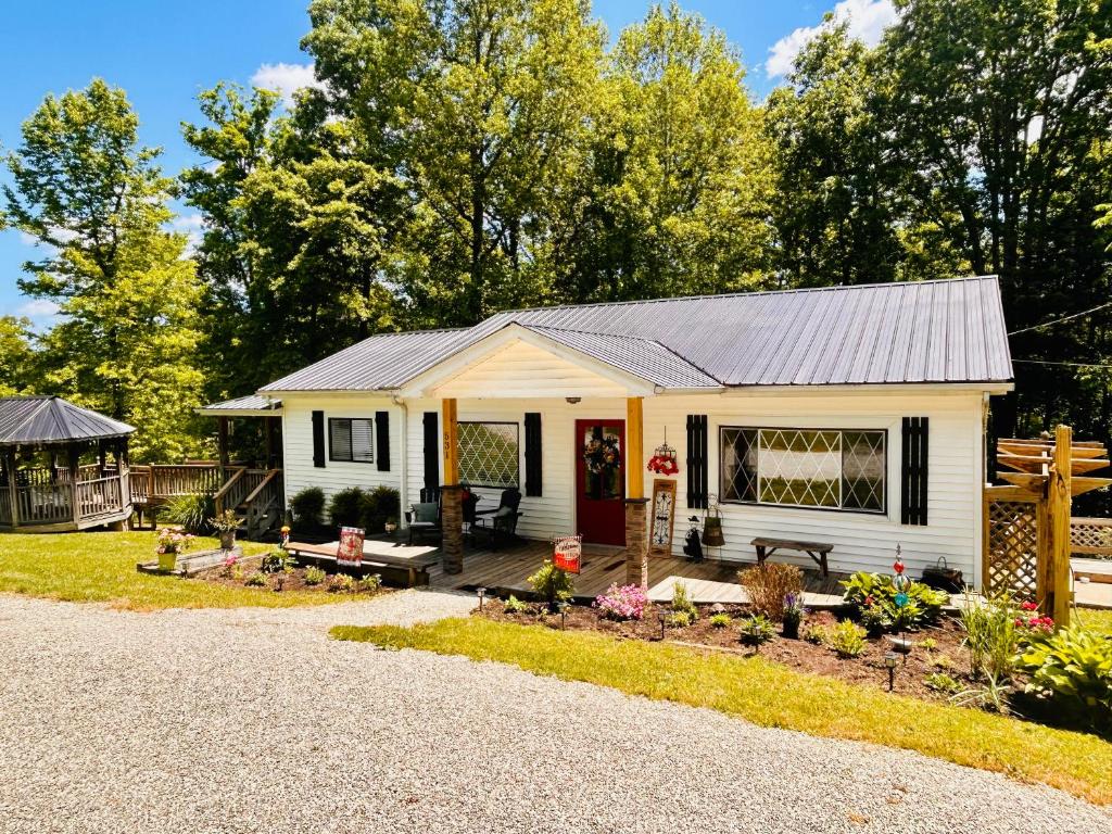 a small white house with a patio and garden at North Star Retreats in Beattyville