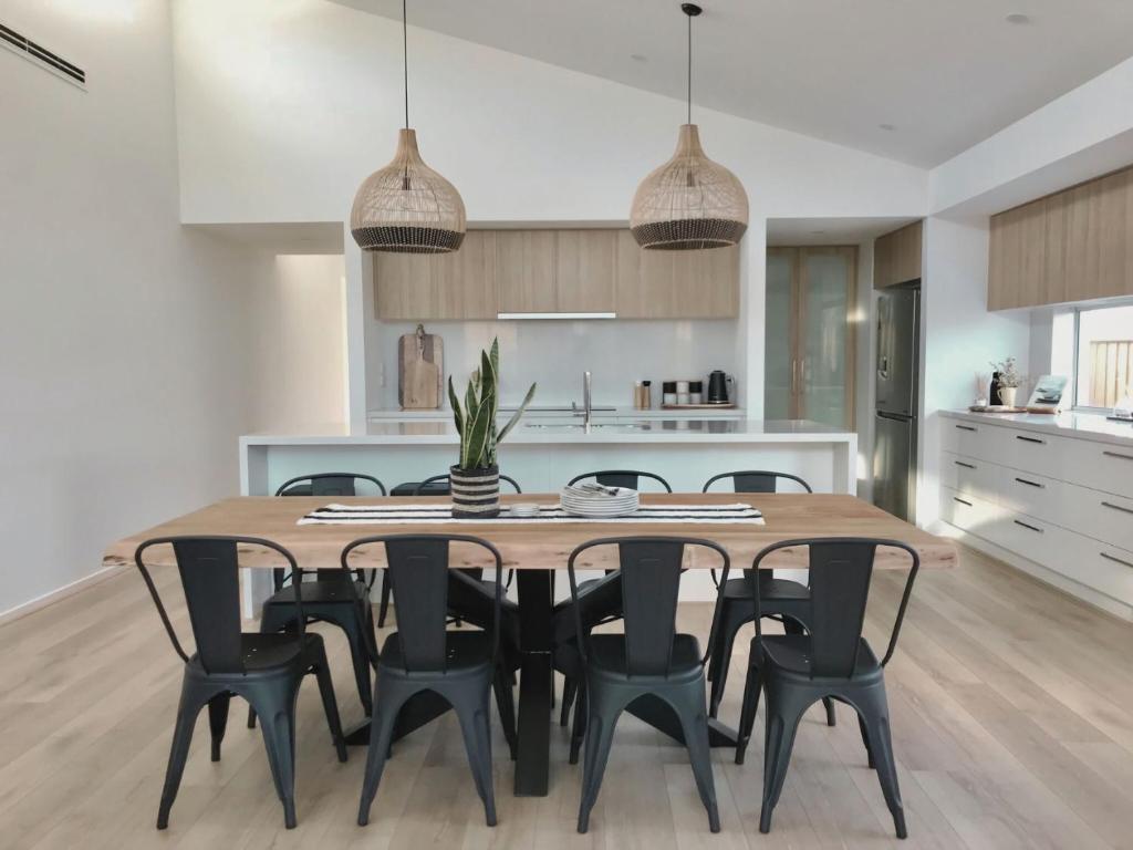 a kitchen and dining room with a wooden table and chairs at Adagio at Lonsdale in Point Lonsdale