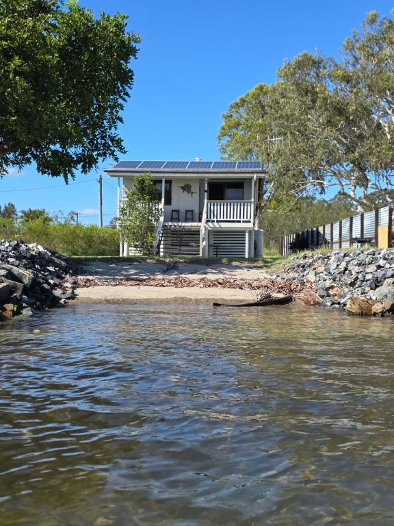 a house on the shore of a body of water at The Crab Shack in Boonooroo