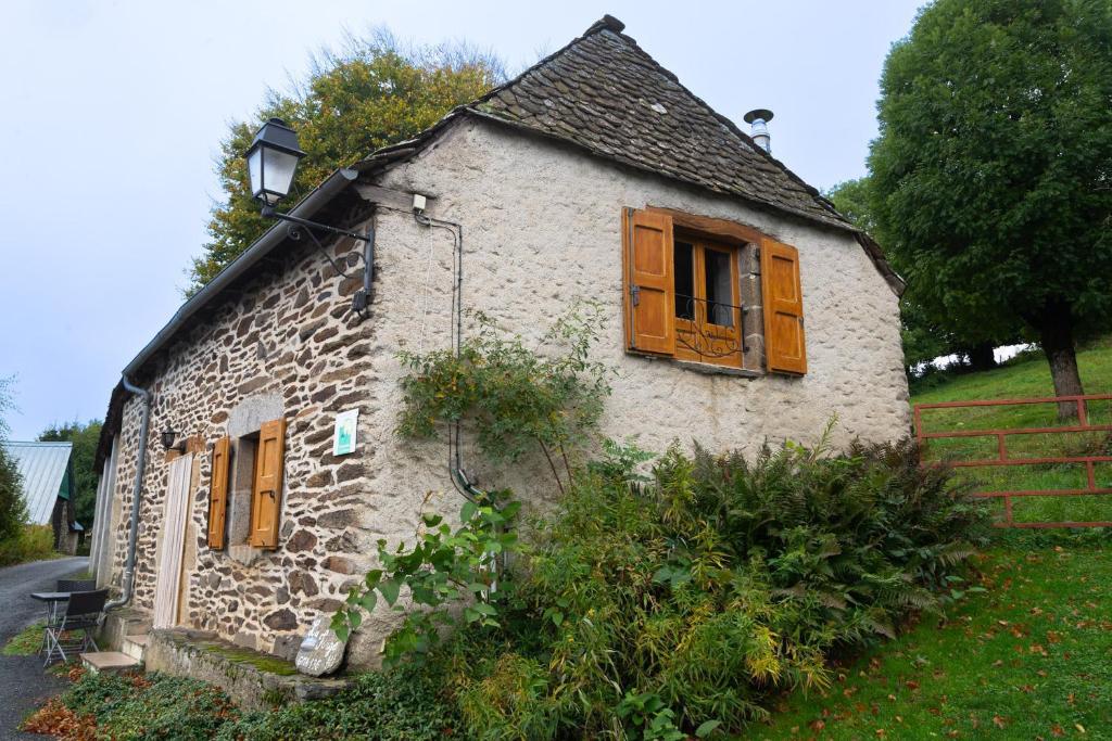 an old stone house with brown doors and windows at La forge 2/5 personnes in Saint-Pierre-de-Nogaret