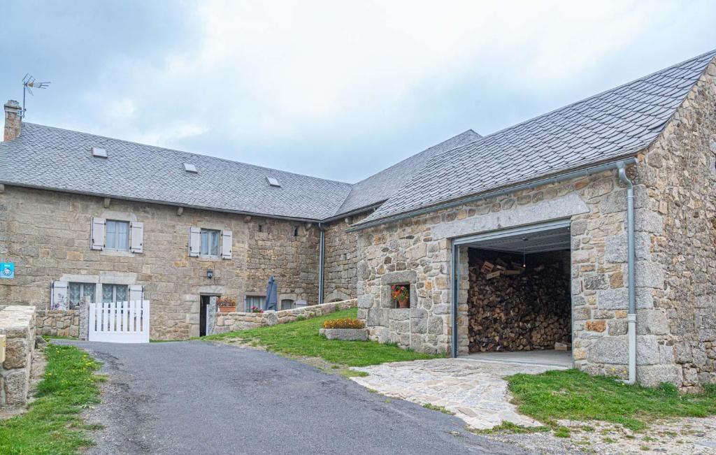a large stone building with a large garage at Gîte de montchamp in Arzenc-dʼApcher
