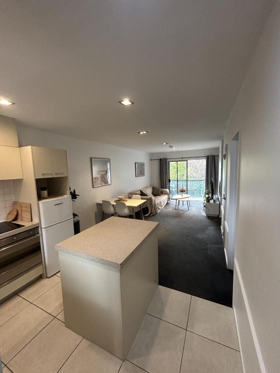 a kitchen and a living room with a table at Wānaka Edge Retreat in Wanaka