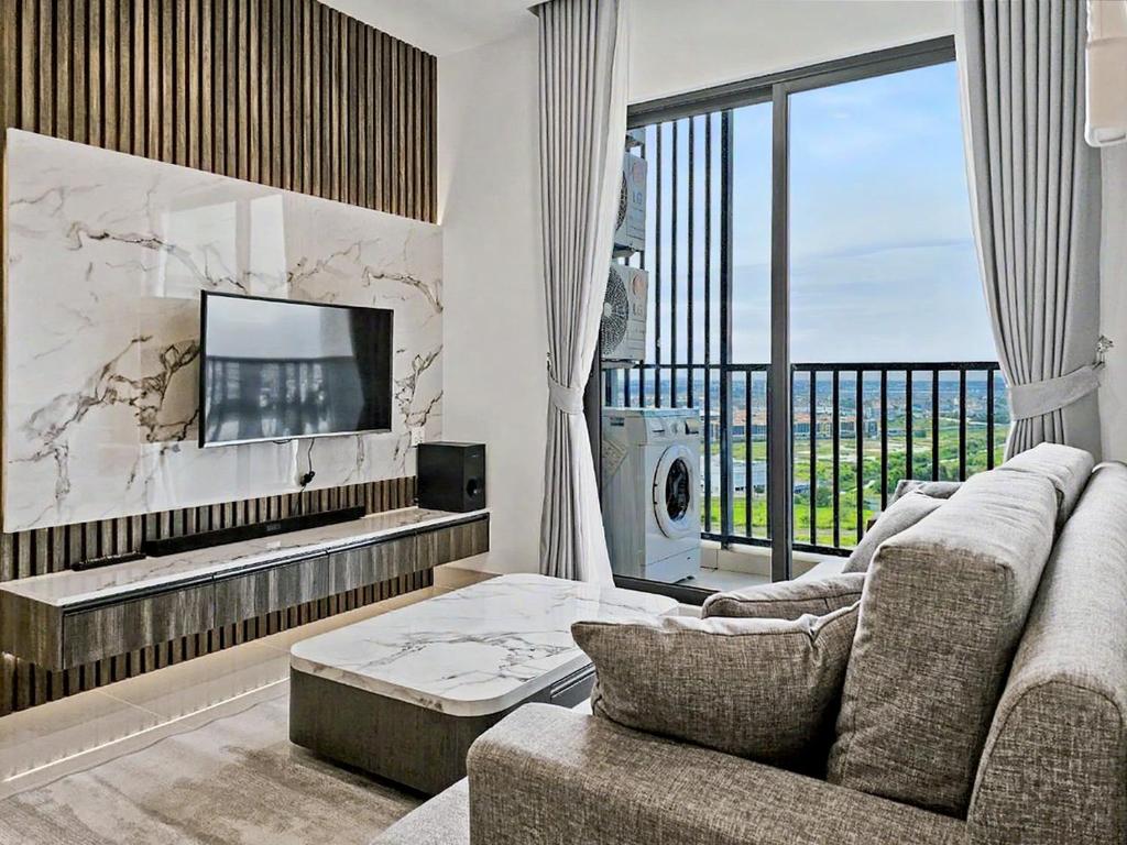 a living room with a couch and a tv at Modera Suites at Parkland Condo TK in Phnom Penh