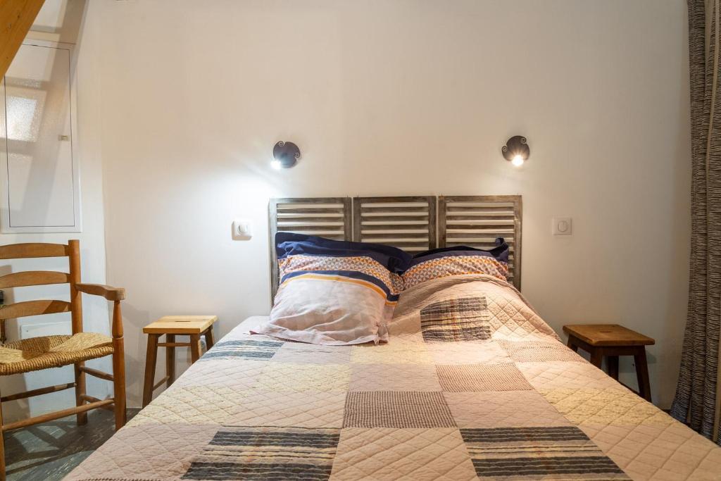 a bedroom with a bed and a chair and lights at Le gîte du comte 2/3 personnes in Saint-Germain-de-Calberte
