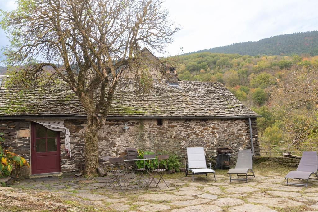 a group of chairs sitting outside of a stone house at Ecogîte nature de bieisses in Quézac