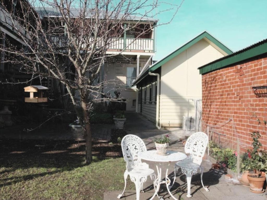 a patio with two chairs and a table in a yard at Doongarra in Queenscliff